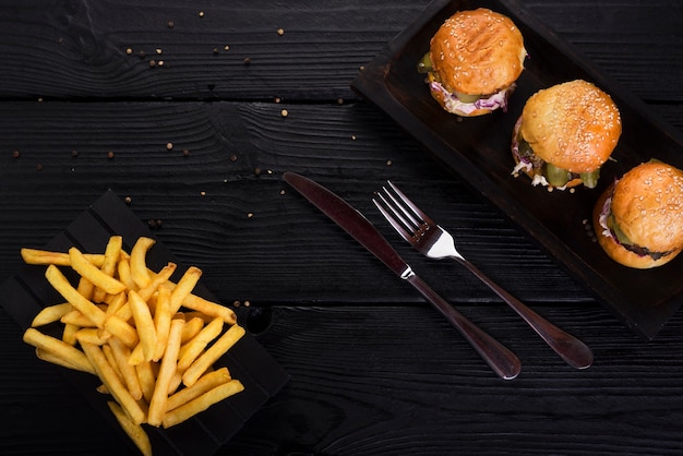 Hambúrgueres de fast-food com batatas fritas e talheres