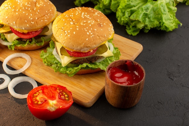 Hambúrgueres de frango com queijo e salada verde na mesa de madeira e sanduíches fast-food