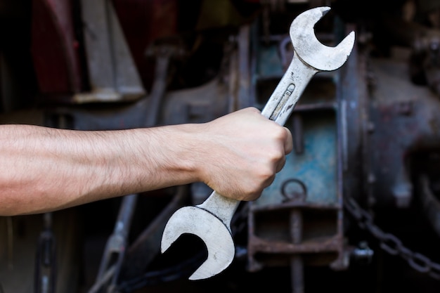 Foto grátis hand holding wrench on dark background