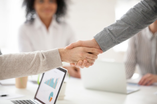 Handshaking de parceiros de negócios na reunião do grupo fazendo investimento de projeto, closeup