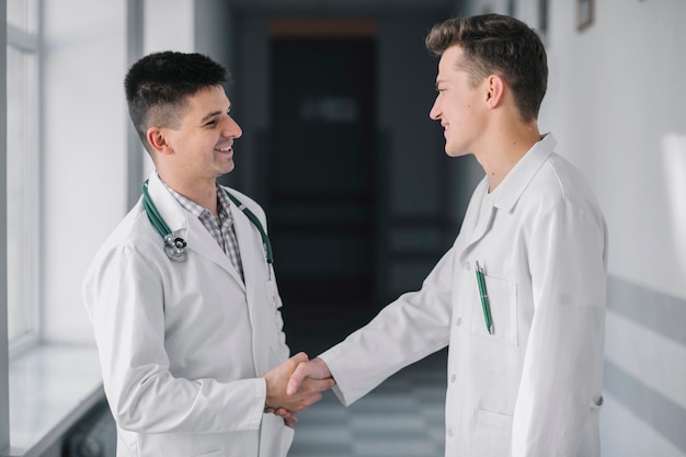 Handshaking dos médicos alegres no hospital