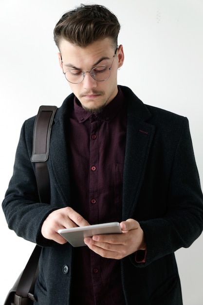 Handsome young man usando seu tablet digital. Isolado no branco.