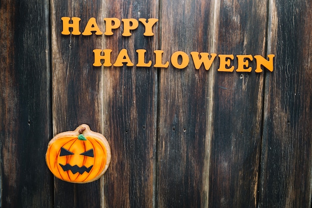 Foto grátis happy halloween inscrição e jack-o-lantern cookie