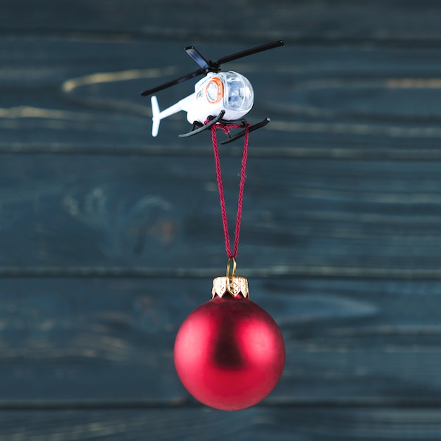 Foto grátis helicóptero de brinquedo carregando enfeite de natal