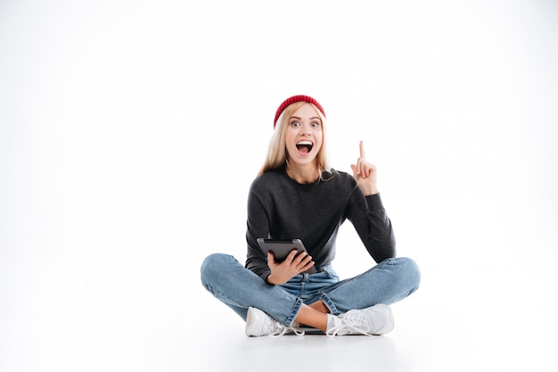 Hipster feminino feliz sentado com computador tablet