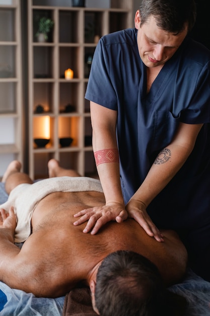 Homem a dar massagem ao paciente
