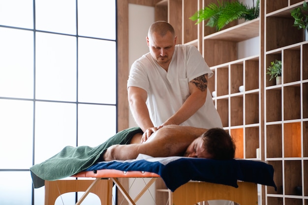 Foto grátis homem a fazer uma massagem profissional.
