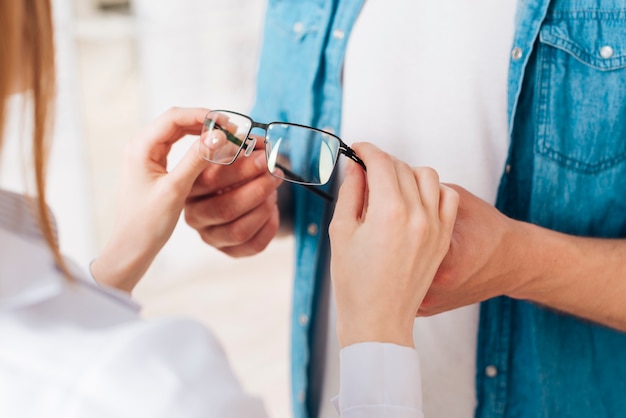 Foto grátis homem à procura de novos óculos no optometrista