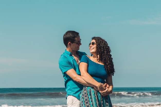 Homem, abraçando, mulher sorridente, ligado, praia