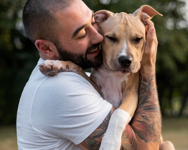 Homem abraçando seu pitbull amigável