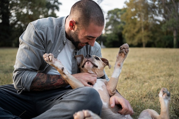 Homem abraçando seu pitbull amigável