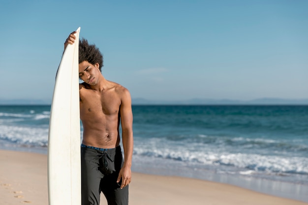 Homem adulto americano africano cansado depois de surf