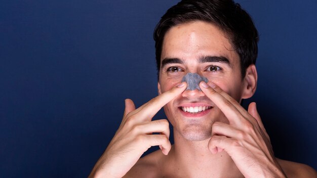 Foto grátis homem adulto, aplicando o produto de cuidados da pele