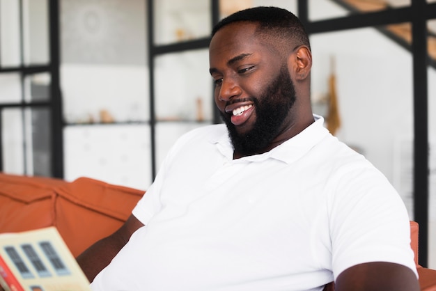 Foto grátis homem adulto bonito lendo em casa