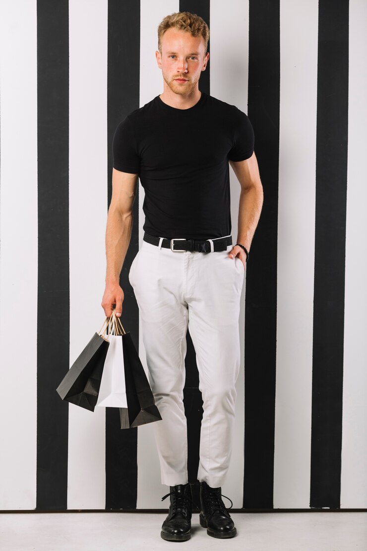 Foto grátis homem adulto bonito segurando sacolas de compras