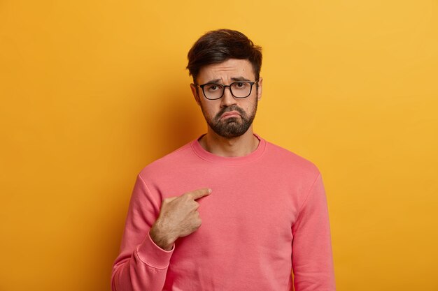 Homem adulto chateado e desapontado aponta para si mesmo, descontente por ter sido escolhido para punir