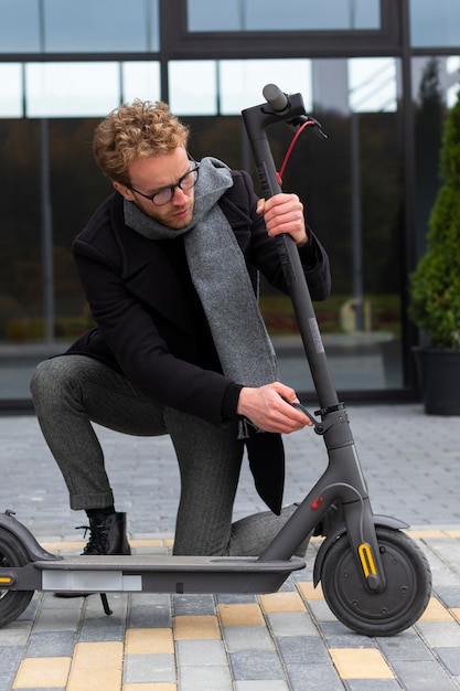 Homem adulto consertando sua scooter elétrica