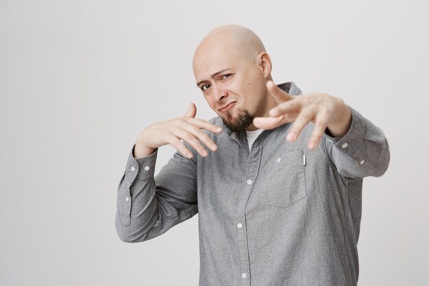 Homem adulto de barba careca cantando rap e dançando hip hop