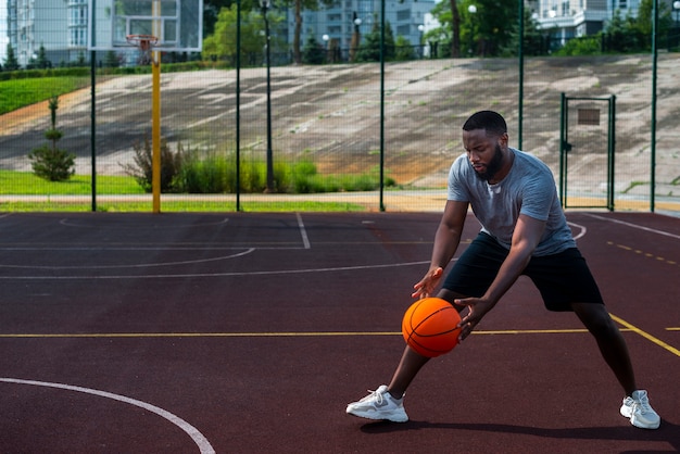 Homem africano, bater bola, ligado, quadra basquete