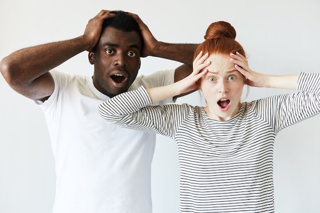 Foto grátis homem africano com camiseta branca e mulher caucasiana ruiva com top listrado