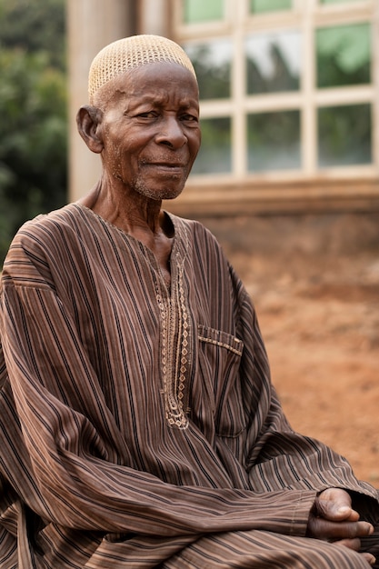 Foto grátis homem africano de tiro médio sentado ao ar livre