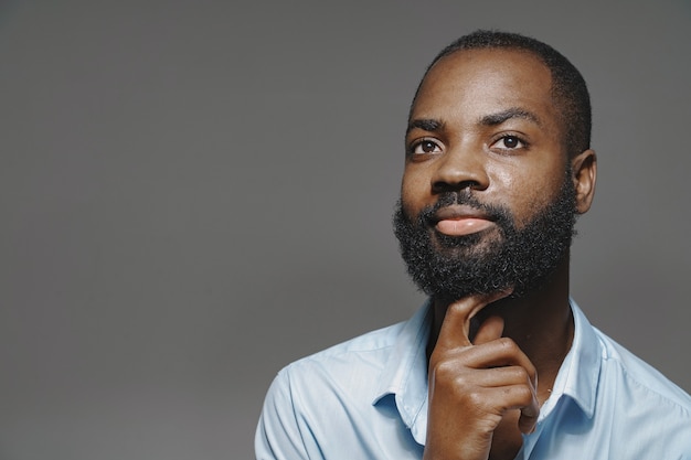 Foto grátis homem africano em um estúdio. parede branca. homem de camisa azul.