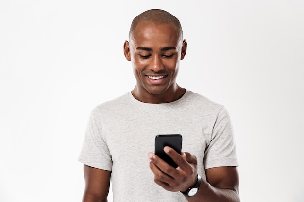 Foto grátis homem africano sorridente usando smartphone