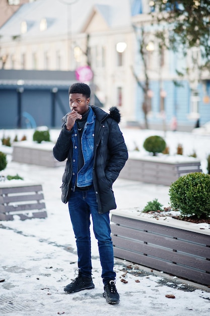 Homem africano usa jaqueta no clima frio de inverno posado ao ar livre