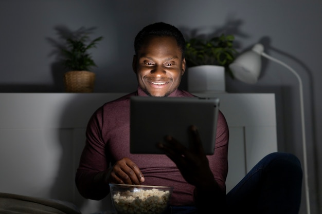 Foto grátis homem afro-americano assistindo serviço de streaming em ambientes fechados