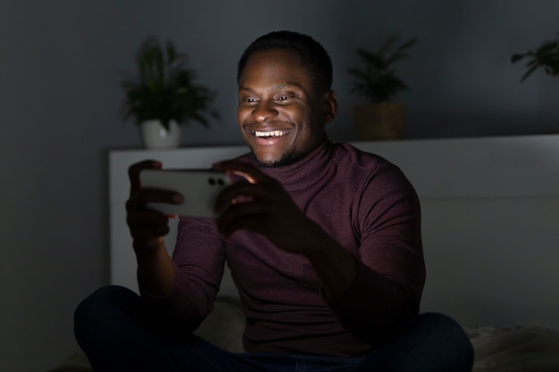 Foto grátis homem afro-americano assistindo serviço de streaming em ambientes fechados
