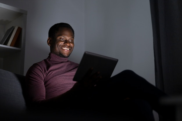 Homem afro-americano assistindo serviço de streaming em casa sozinho