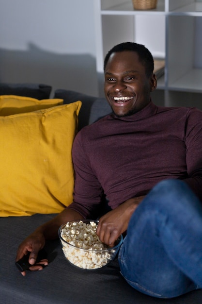 Foto grátis homem afro-americano assistindo serviço de streaming em casa