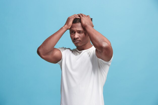 Homem afro-americano com dor de cabeça. Isolado sobre a parede azul