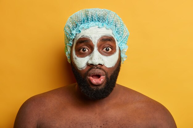 Foto grátis homem afro-americano com máscara de argila, expressa emoções positivas isoladas