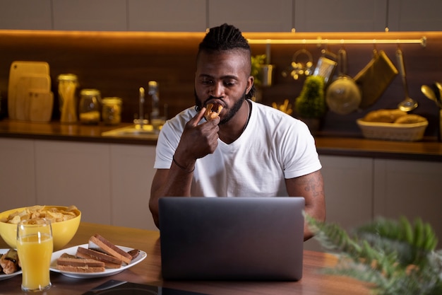 Homem afro-americano comendo tarde da noite