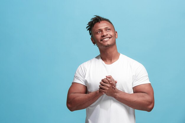 homem afro-americano de negócios feliz em pé e sorrindo contra o azul