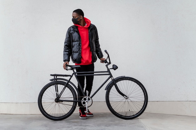 Foto grátis homem afro-americano e sua bicicleta.