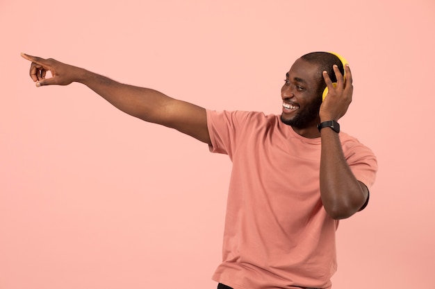 Foto grátis homem afro-americano expressivo ouvindo música em fones de ouvido