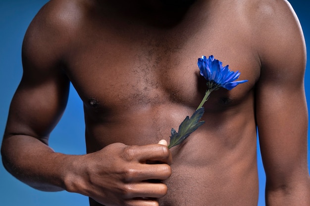 Homem afro-americano segurando uma flor azul