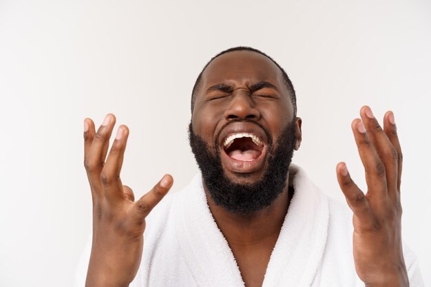 Homem afro-americano vestindo um roupão de banho com surpresa e emoção feliz isolado sobre fundo branco