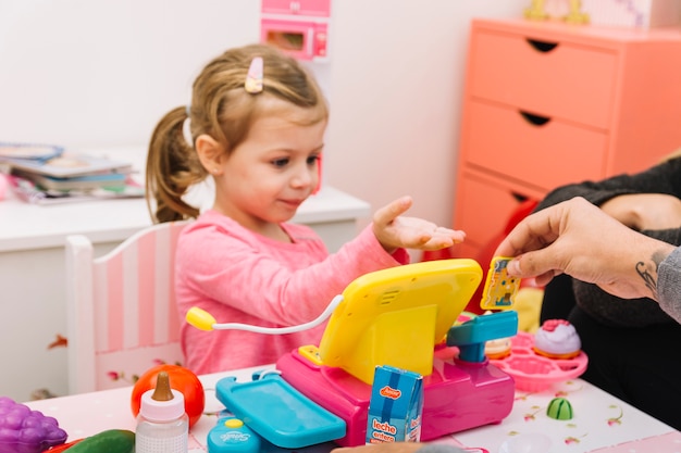 Homem, ajudando, seu, filha, enquanto, tocando, brinquedo