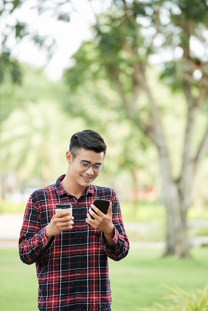 Homem alegre com café e telefone