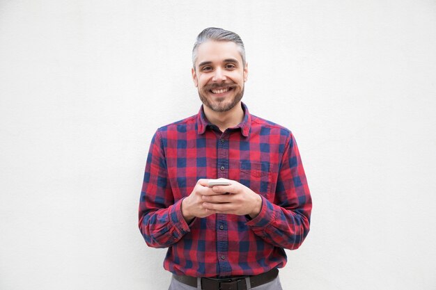 Homem alegre com smartphone sorrindo