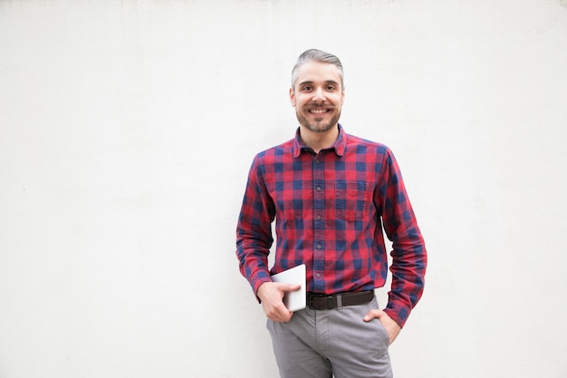 Foto grátis homem alegre com tablet digital olhando