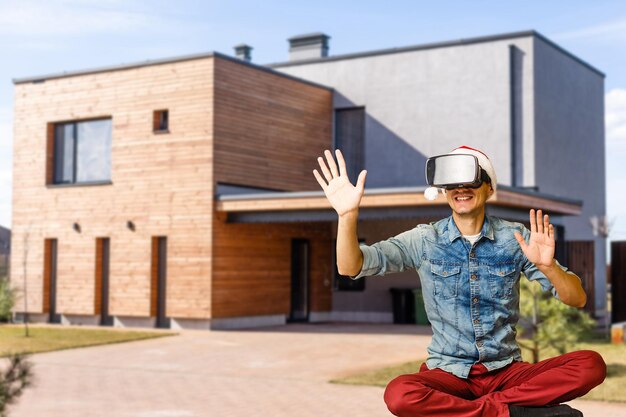 Homem alegre em óculos virtuais na frente da casa nova.