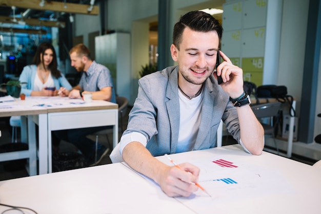 Homem alegre falando no telefone durante o trabalho