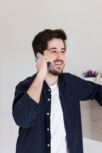 Homem alegre, falando no telefone no escritório