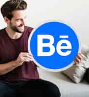 Foto grátis homem alegre, mostrando um ícone do behance