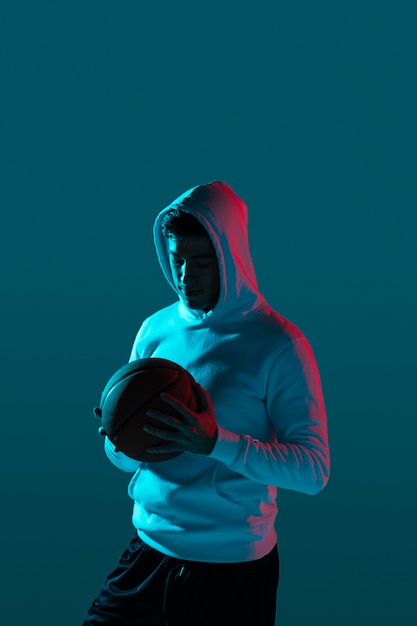 Homem alto, jogando basquete com luzes legais