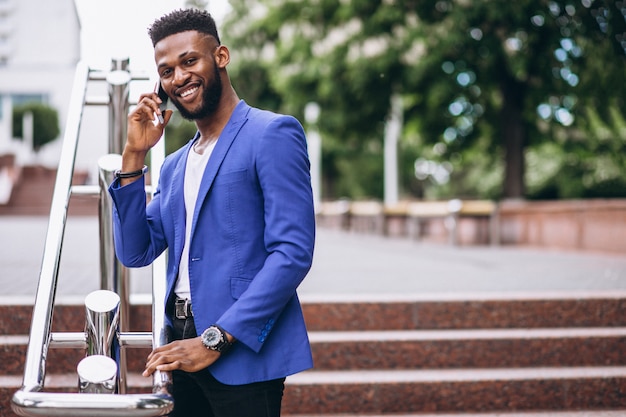 Homem americano africano, em, casaco azul, usando, telefone